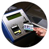 A hand tapping a CharlieCard at a MBTA fare gate.